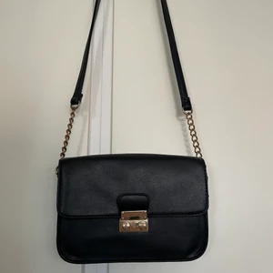 Svart väska - Svart väska med gulddetalj. Rymlig.