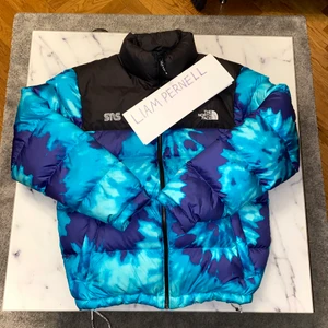 The North Face Nuptse x Sneakersnstuff - Nuptse Jacket Scuba Blue Tie Dye  Jackan är i mycket bra skick. Köpt från SNS 2019.