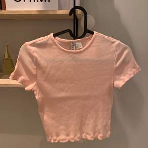 Vanlig ljus rosa t-shirt som jag även säljer i svart! Storlek s och är ribbad! Ser lite genomskinlig ut men är värkligen inte det, aldrig anväd och köpt för 69 kr om jag minns rätt, köp för 30 kr + frakt, tryck inte på köp direkt!!