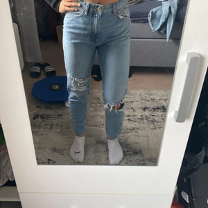 Jeans med hål i  - Ett par helt oanvända ljusblåa Jens från Gina Tricot, i storlek 34. 