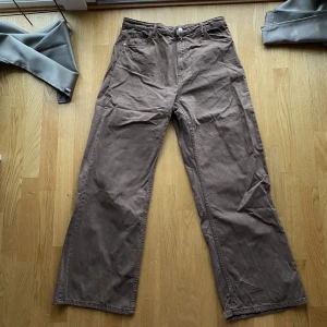 Högmidjade byxor från Bershka - Högmidjade byxor med vida ben från Bershka i strl 42. Använda fåtal gånger. Fungerande fickor på både fram- och baksida.