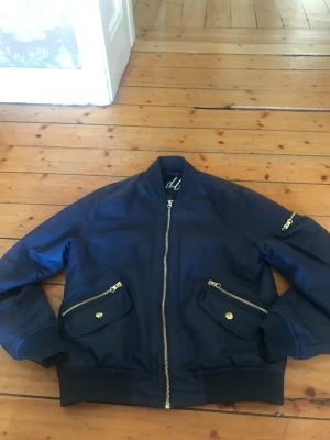 Bomberjacka - Fin bomberjacka som är mörkblå med oranged foder. Passar bra som en vår/höst jacka eftersom att den inte är jättevarm eller jätte kall. Skriv för frågor eller intresse.