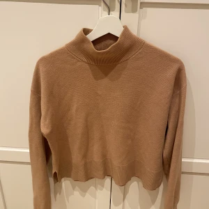 & Other Stories tröja med hög krage  - Fin tröja från Other Stories i Ljusbrun / kamel färgad med hög krage.  Tröjan är i gott!   Kan även skickas :) 