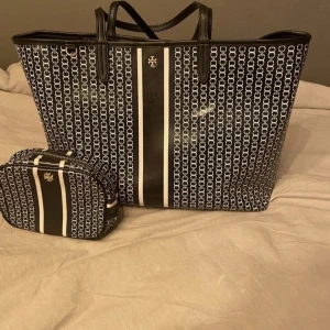 Tory Burch Väska & Plånbok - Tory Burch Väska och plånbok. Köpt på miinto. Säljer den här åt min mamma. Blå med svart färg. Väskan 700kr  Plånbok 300kr