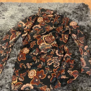 Turtle neck tröja - Skitsnygg blomster tröja som tyvärr är för liten för mig. Den är av mesh tyg men syns inte igen så den har två lager