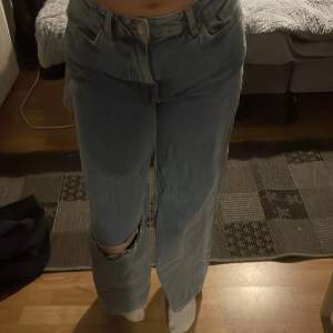 Ett par blåa baggy jeans med ett hål, i väldigt fint skick. Stl 26-30.