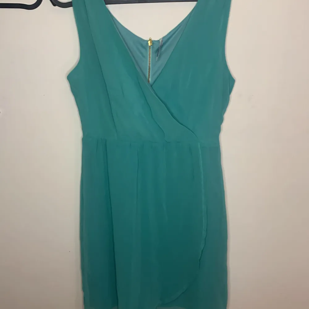 Färgen på klänningen är turkos blå nästan grön kan man säga, den är underbar och ser ut som en wrap-topp tillsammans med en luftig kjol! Du får den nu 50% off. Klänningar.