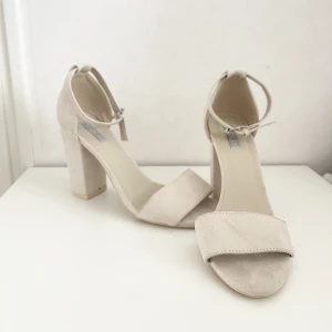 Oanvända beiga klackskor med tjockare klack - Osnvända Beiga klackskor från Nelly. Jag säljer även likadana klackskor med smal klack och finns på min Plick sida.