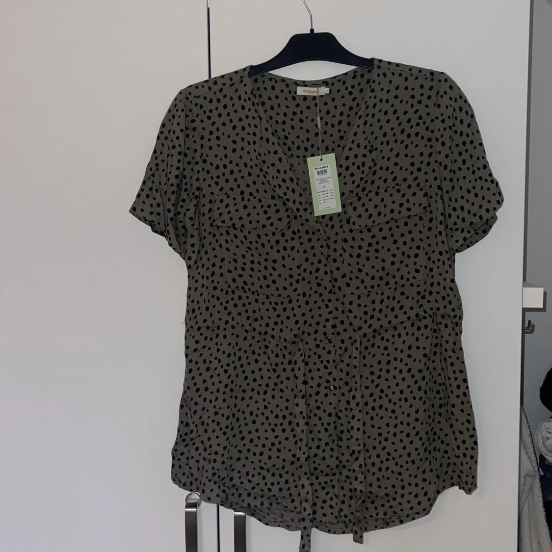 Grön blus med svarta prickar