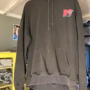 En svart hoodie från H&M med MTV tryck både fram och bak. Har lite sprickor i trycket men den är i bra skick utöver det. Storlek medium. Själv är jag 187cm