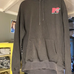 Svart MTV-hoodie - En svart hoodie från H&M med MTV tryck både fram och bak. Har lite sprickor i trycket men den är i bra skick utöver det. Storlek medium. Själv är jag 187cm