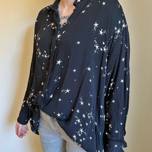 Svart skjorta med stjärnmönster - Svart skjorta från Weekday med vitt stjärnmönster. Använt, men gott skick. Alla knappar är kvar på skjortan. Oversize passform.