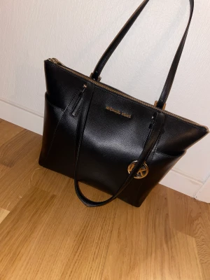 Michael kors väska äkta - Äkta Michael kors väska i fint skick. Använd vid fåtal tillfällen, äkthetsbevis finns med. 