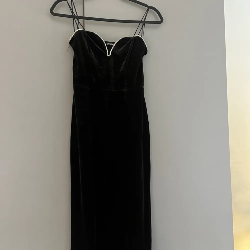 En svart sammets klänning med silver strass. Ny med prislappen kvar. Klänningen är från Ginatricot och slutsåld på deras hemsida. Storlek XS med passformen är något stor (passar en S/M). Klänningar.