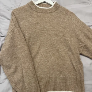 Stickad tröja  - En fin stickad tröja från H&M i en ljus beige/brun färg. Tröjan är i strl XS men är väldigt stor i storleken och strechig. Köpare står för frakten