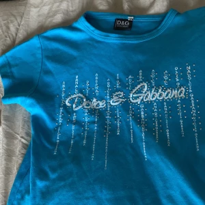 Dolce & Gabbana topp  - Intressekoll för denna coola croppade Dolce & Gabbana topp! Köpt på en Thrift store men ändå bra skick! Några stenar har ramlat av, själv använder denna topp typ två gånger! 