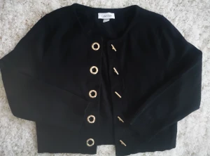Calvin Klein kort kofta S - Calvin Klein kort kofta Svart med guldknappar Den är i mycket bra skick 60% bommul 40% viscose  Storlek S men jag tycker att det går bra för nån som är M också  Bara använd två gånger