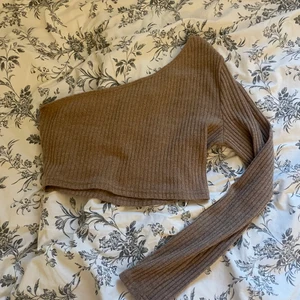 Ribbad höstig topp - En ribbad topp med en arm, väldigt höstig färg! Super bekväm. Storlek L men sitter bra som en M/ S ( jag har vanligtvis S/XS lite stor för mig) BRUN - BEIGE ribbstickning