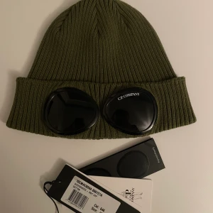 Cp company mössa - Säljer nu min cp company, den är i grön färg och köp från cp companys hemsida. Den är i väldigt fint skick och inga repor alls! Har tags och en påse man får med när man köper den!  Hör av dig om du har frågor!