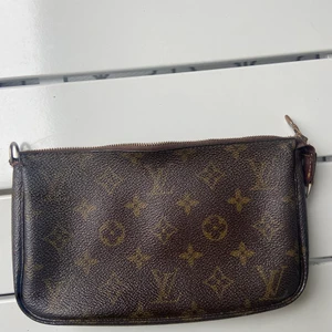 Louis Vuitton pochette  - Säljer denna Louis Vuitton pochette. Väskan är i bra skick förutom att bandet är sönder där av priset. Det går att köpa ett nytt eller laga. Skriv om det är något du undrar eller om du vill ha fler bilder