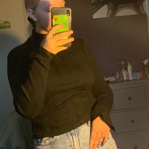 Polotröja  - Svart långärmad tröja med ”krage” och snitt vid händerna. Använd en gång 