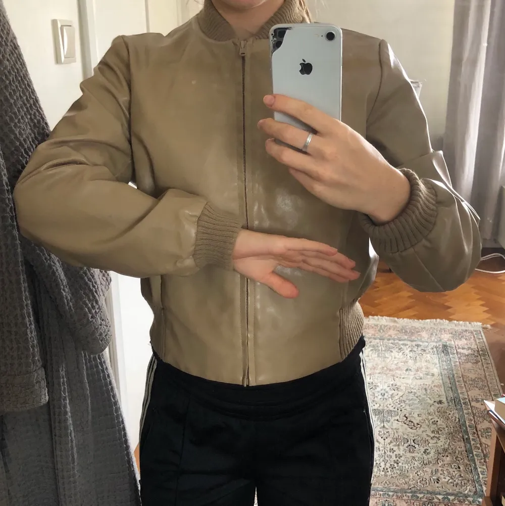 En beige bomberjacka i vinyl / läderimitation. Superfin passform och bra skick. Jag bär vanligtvis 34/36.. Takit.