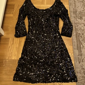 Glitter klänning - Svart glitterklänning som är jätte fint urringad, nästan lite off-shoulder. Ser ut att vara lite flowig men sitter helt tajt på kroppen. 