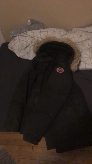 canada goose jacka - en riktigt bra vinter jacka köpte den för 9 månader sen för 12,000kr fortfarande i riktigt bra skick, den är mörk grön, den pasar både kvinnor och män 