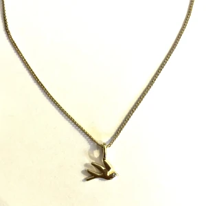 Pilgrim halsband svala - Ett jätte gulligt guldfärgat halsband från pilgrim med en svala på, använd 1 gång o är i nyskick, nypris 349kr 