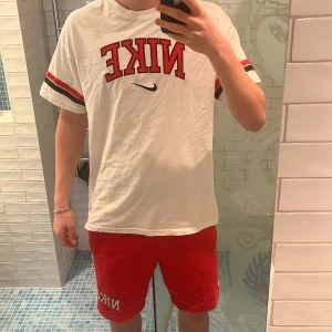 Nike shorts/T-shirt till salu för ett bra pris!🤝😁🤝 - Säljer dessa röda shorts och denna vitröda T-shirt tillsammans!  Säljs till ett väldigt bra pris👍 Nypris va 1000kr Jättesköna och oanvända!