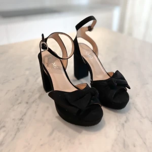 Svarta klackar med rosett - Svarta klackar med rosett från Tiamo.