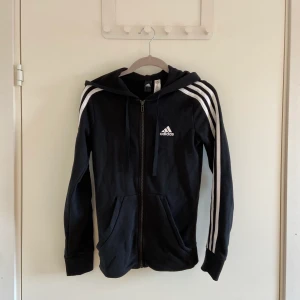 Adidas zip hoodie - köpt 2017/2018 i en Adidas store för 600kr. sparsamt använd därför är den fortfarande i ett jättebra skick, inga slitningar eller fläckar.  det är en dammodel och storlek XS vilket ger en tight fit som framhäver dina former!