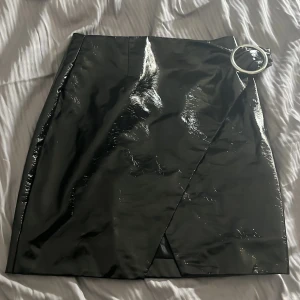 Skinnkjol NAKD - Säljer denna SÅ FINA (!!!!) skinn/lack-kjol från NAKD i storlek 38. Gjorde ett försök att visa hur den knyts på bild, men skriv privat för fler bilder!! I bra skick. Perfekt till hösten❤️❤️❤️❤️❤️