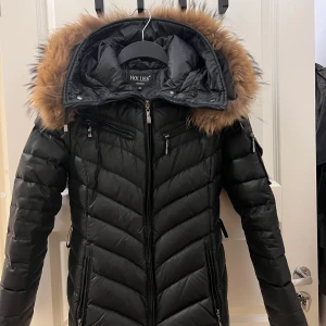 Hollies long cortina - Säljer denna hollies jacka nu! Finns två skador, ett jack på undersidan av luvan som inte syns samt att en knapp från luvan försvunnit💓Tillkommer även ett midje bälte. Skriv gärna för fler bilder!  (Äkta päls)