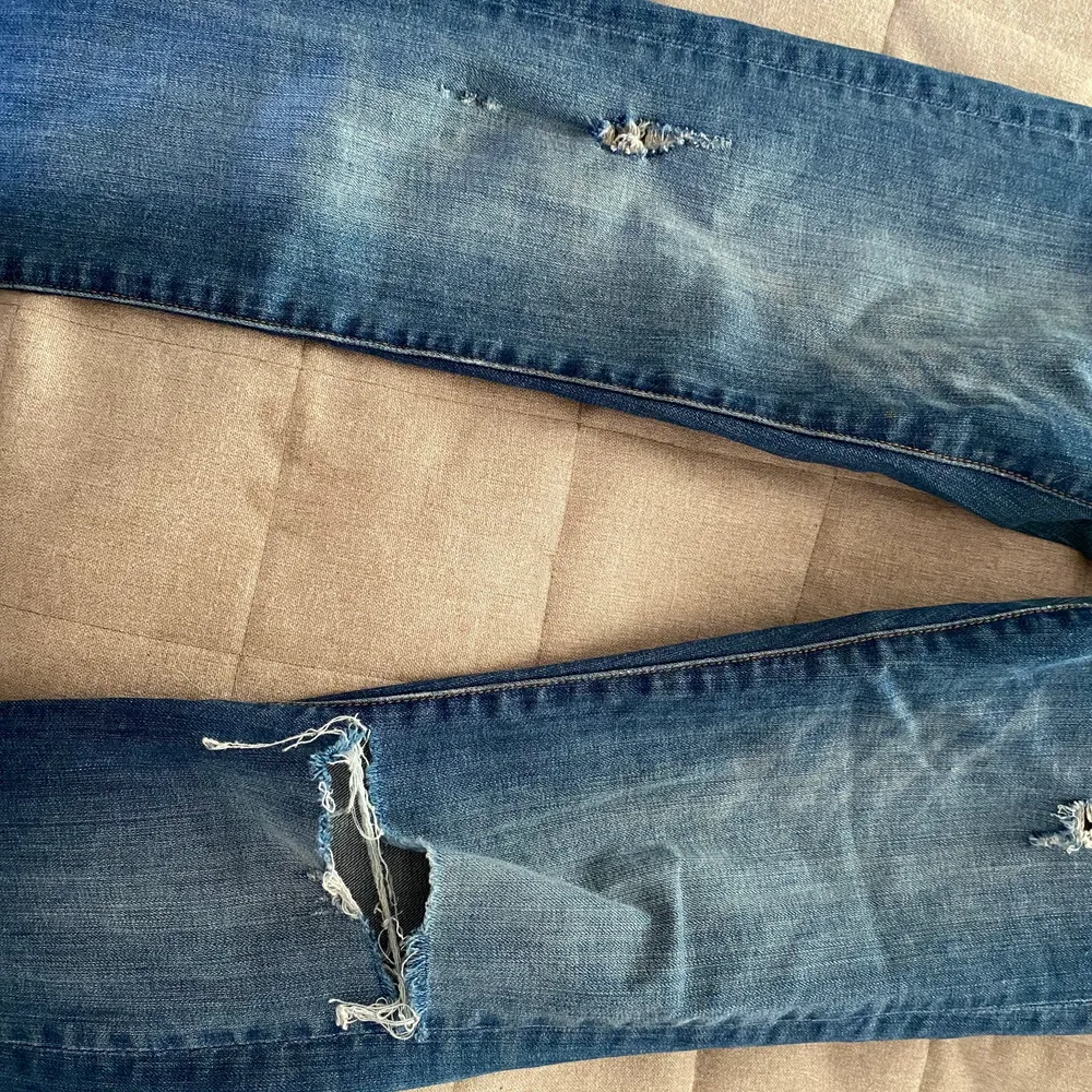Högmidjade Stuprörs jeans med ett hål i ena knät. Strl 25/30. Jeans & Byxor.