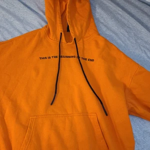 Från Brooklyn's own - Det är en orange tjocktröjan. Det står this is The beginning of The end på engelska med svart text och snörena är svarta också.