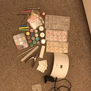  Nagel Kit  - Det kommer med en nagel lampa en nagel Geleiga masa olika glitter i nagelfil en buffer en nagelklipare nagelolja tre olika tippar tre olika nagelklstermärken en pänsel och lite nagel verktyg. Inget av sakerna har används förutom lampan.
