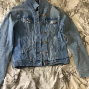 Blåjeansjacka  - Ljusblå jeansjacka i använt skick. Utspringspris 150kr