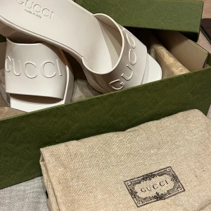 Gucci Rubber slide sandal 39 - Gucci Rubber Slide Sandal i vit. Storlek 39. Köpta på Guccis hemsida i april i år. Nypris 3839SEK. Sparsamt använda!  Säljer för 2500, kan gå ner i pris vid snabb affär.   Köparen står för frakt, kan mötas i centrala Gbg. Betalning via Swish🔆