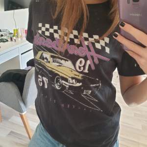 En svart t-shirt från gina tricot med en gul bil på. Tröjan har även lila och vita detaljer. Säljer den eftersom den är för liten och inte kommit till användning tyvärr.  Det är tre små hål som knappt syns, på ärmen så har även sömmen gått upp lite 