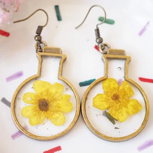 Yellow flower in round bottom flask - I collected this super cute flower during spring - summer 2021 in Sweden. I carefully pressed on wooden flower press for a week. Then I embed with uv-resin. 