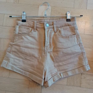 Tan Jeansshorts  - Khak i/ ljusbruna / tan mini jeansshorts stl XS. Använda men i bra skick. Fickor fram och bak.