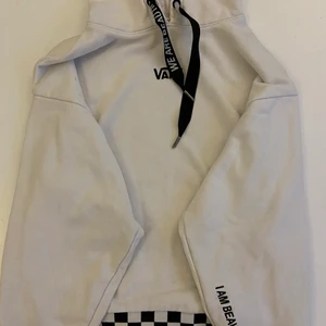 Vans Hoodie  - Vit hoodie från Vans med svart text. Hoodien är i storlek M i bra stick.