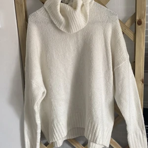 Stickad vit tröja - Säljer denna stickade vita tröja med hög krage från lager157. Den är i storlek L men sitter som jag visat på bilden bra på mig som brukar ha S. Så den är större men sitter väldigt bekvämt och bra ändå! Köparen står för frakten!