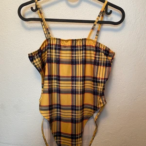 Rutig shein body  - Rutig shein body i stl s/36 med justerbara band. Knappar att stänga bodyn med väldigt high-cut. Stretchigt material så kan passa M också. Vid leverans tillkommer frakt kostnad.