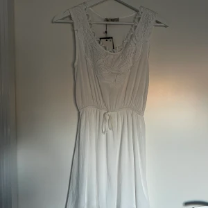 Vit klänning - Säljer även denna för att den inte passar. Aldrig använt och prislappen är fortfarande kvar. Även denna är perfekt för konfirmation eller student och sitter så fint på. 