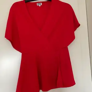 En röd och fin blus från Bubbleroom i storlek 38. Ett midjesnöre medföljer. Blusen är i nyskick och är använd 3 gånger. 