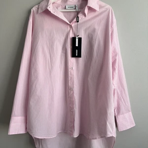 Randig skjorta fr Weekday strl.36 -ny!  - Skjorta i tunn, ekologisk bomull från Weekday. Oversize strl.36 så passar därför både större och mindre beroende på önskad passform. Helt ny med tags kvar! Fin över bikinin eller till en klänning.                                                                                   Kan skickas eller hämtas upp i centrala Sthlm. 