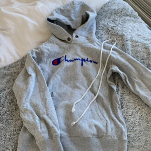 Champion hoodie - Säljer min ljusgrå champion hoodie då den blivit för liten, tjockt och kvaletativt material. 150kr köparen står för frakt. Snörerna har åkt ut men går att sätta tillbaka igen.