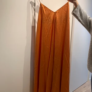Silkes klänning  - Silkes klänning i orange. Aldrig använd. Storlek S men passar M också. 